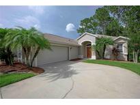 Inviting home featuring a two-car garage, landscaped yard, and elegant entryway with arched alcove at 189 Perfect Dr, Daytona Beach, FL 32124