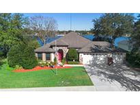 Beautiful lakefront home with a three-car garage and meticulously landscaped lawn at 524 Quail Hill Dr, Debary, FL 32713