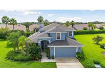 Two-story house with a gray roof, two-car garage, and landscaped yard at 5423 Swordfern Ct, Port Orange, FL 32128