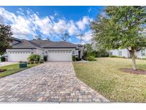 Attractive home exterior with a paved driveway and landscaped lawn at 751 Aldenham Ln, Ormond Beach, FL 32174