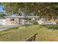 Tan brick house with a white door, large windows, and a well-manicured lawn at 118 N Sunland Dr, Sanford, FL 32773