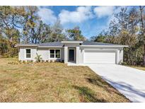 Charming single-story home with a two-car garage and neatly manicured lawn at 1205 2Nd St, Orange City, FL 32763