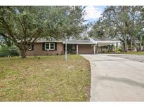 Ranch style home with carport and mature landscaping at 139 Floridana Rd, Debary, FL 32713