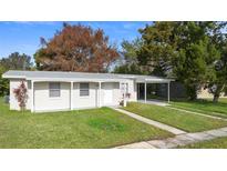 Newly renovated single story home with carport and well-manicured lawn at 1462 Wiltshire Ave, Deltona, FL 32725