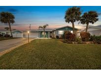 Inviting home exterior featuring a well-manicured lawn and palm trees at 15 Longfellow Cir, Ormond Beach, FL 32176