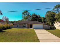 One-story house with a white garage door and a well-maintained lawn at 1520 3Rd Ave, Deland, FL 32724