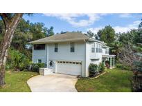 Two-story house with attached garage and landscaped yard at 163 Laurelwood Ln, Ormond Beach, FL 32174