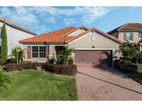 Tan house with brown roof and garage; lush landscaping at 167 Ancona Ave, Debary, FL 32713