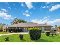 Brick ranch house with landscaped lawn and circular driveway at 2501 Alton Rd, Deltona, FL 32738
