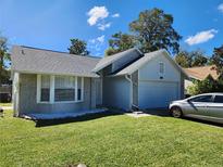 Cute one-story house with a gray roof and well-manicured lawn at 3566 Red Pontiac Dr, Port Orange, FL 32129