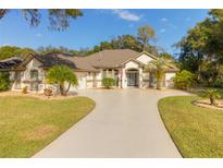 Single-story house with a circular driveway and landscaped lawn at 3605 Galway Ln, Ormond Beach, FL 32174