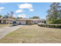 Brick ranch house with carport, landscaping, and large yard at 783 S Atmore Cir, Deltona, FL 32725