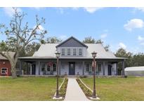 Gray farmhouse with wraparound porch and stone accents at 1330 E Taylor Rd, Deland, FL 32724