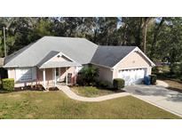 Charming single-story home with a well-manicured lawn, attached garage, and inviting front porch at 1900 Knolton Ave, Orange City, FL 32763