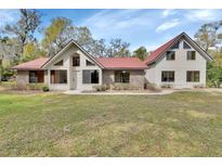 Charming home with a red roof, light siding, brick accents and an expansive front lawn at 2170 Wilmhurst Rd, Deland, FL 32720