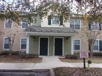 Tan two-story townhome with green accents and two front doors at 2770 Coastal Bay Dr # 3-103, Orange City, FL 32763