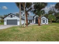 Beautiful single-story home with gray roof and attached garage at 130 Old Sunbeam Dr, South Daytona, FL 32119