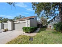 Front view of charming townhouse with attached garage and well-manicured lawn at 235 Pine Cone Trl, Ormond Beach, FL 32174