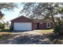 Cute ranch home with a white garage door and mature landscaping at 3019 N Covington Dr, Deltona, FL 32738