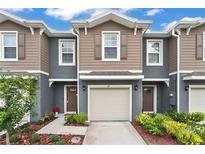Two-story townhome with neutral siding and a two-car garage at 37 Bella Lago Cir, Port Orange, FL 32129