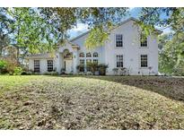 Two-story house with white exterior, landscaping, and large windows at 1450 Alden St, Deland, FL 32720