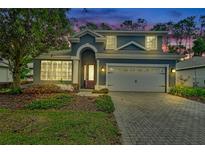 Charming two-story home with a brick driveway, two-car garage, landscaped yard and covered front entry at 204 Wellington Woods Ave, Deland, FL 32724