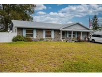 Ranch-style home with brick facade, spacious yard, and American flag at 262 Valencia Rd, Debary, FL 32713