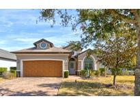 Charming single-story home featuring a brick driveway, manicured lawn, and a symmetrical façade at 3169 Connemara Dr, Ormond Beach, FL 32174