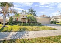 Single-story home with landscaped yard, attached garage, and palm trees at 555 Morgan Wood Dr, Deland, FL 32724
