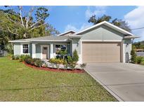 Newly constructed home with attached garage and well-manicured lawn at 731 E Cox St, Deland, FL 32724