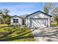 Newly constructed home with a two-car garage and well-manicured lawn at 2210 5Th Ave, Deland, FL 32724