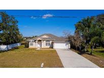 Single-story house with a landscaped lawn, driveway, and attached garage at 2370 Alton Rd, Deltona, FL 32738