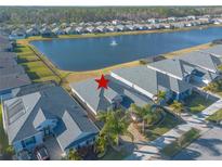 Beautiful aerial view of home with lake, fountain, and landscaping in a desirable community at 238 Venetian Palms Blvd, New Smyrna Beach, FL 32168