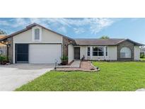 Brick and siding house with a 2-car garage and landscaped lawn at 2625 Sweet Springs St, Deltona, FL 32738