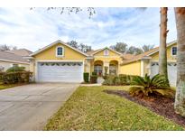 Attractive yellow house with a two-car garage and well-manicured lawn at 3162 Kailani Ct, Ormond Beach, FL 32174