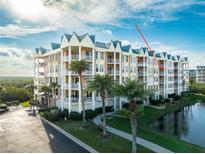 Stunning waterfront condo building featuring manicured grounds, tropical landscaping, and a bright coastal design at 4672 Riverwalk Village # 8406, Ponce Inlet, FL 32127