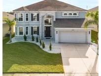 Two-story house with gray exterior, stone accents, and a three-car garage at 6832 Forkmead Ln, Port Orange, FL 32128