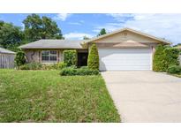 Brick ranch house with a two-car garage and well-maintained lawn at 1016 Martex Dr, Apopka, FL 32703