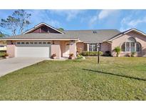 Charming single-story home with a brick facade, well-maintained lawn, and a two-car garage at 2075 Little Farms Ct, Deltona, FL 32738