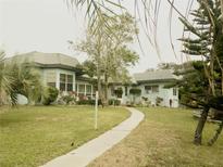 Light blue single story home with a walkway and lush landscaping at 2201 S Peninsula Dr, Daytona Beach, FL 32118