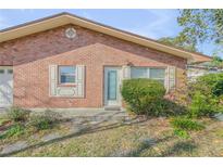 Charming single-story brick home featuring manicured landscaping and covered entryway at 564 Cambridge Cir, South Daytona, FL 32119