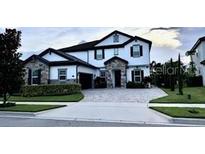 Charming two-story home with a stone-accented facade, manicured lawn, and paved driveway at 6301 Swanson St, Windermere, FL 34786