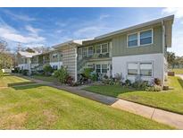 Inviting exterior view of a two-story condo building with well-maintained lawn and landscaped garden at 840 Center Ave # 9, Daytona Beach, FL 32117
