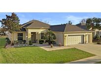 Charming single-story home featuring a well-manicured lawn, neutral paint, and an attached two-car garage at 9580 Sw 71St Loop, Ocala, FL 34481