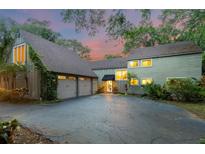 Inviting two-story home featuring an attached two-car garage, lush landscaping, and a well-maintained driveway at 120 Beach St, Ponce Inlet, FL 32127