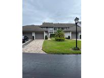 Charming townhouse with attached garages and well-maintained front yard landscaping on a cloudy day at 168 Olive Tree Cir # 168, Altamonte Springs, FL 32714