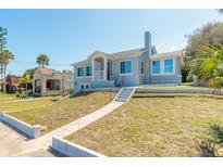 Charming blue two-story home with a landscaped yard and inviting front porch at 408 Wisteria Rd, Daytona Beach, FL 32118