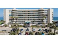 Lovely exterior view of a luxury condominium building with palm trees and parking at 4631 S Atlantic S Ave # 8201, Ponce Inlet, FL 32127
