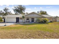 Charming single-story home with a well-manicured lawn and inviting front porch at 480 Columbus Ave, Orange City, FL 32763