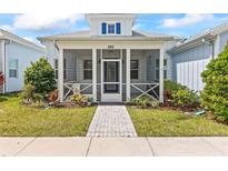 Charming light blue single-story home featuring a cozy front porch and meticulously landscaped yard at 562 Landshark Blvd, Daytona Beach, FL 32124